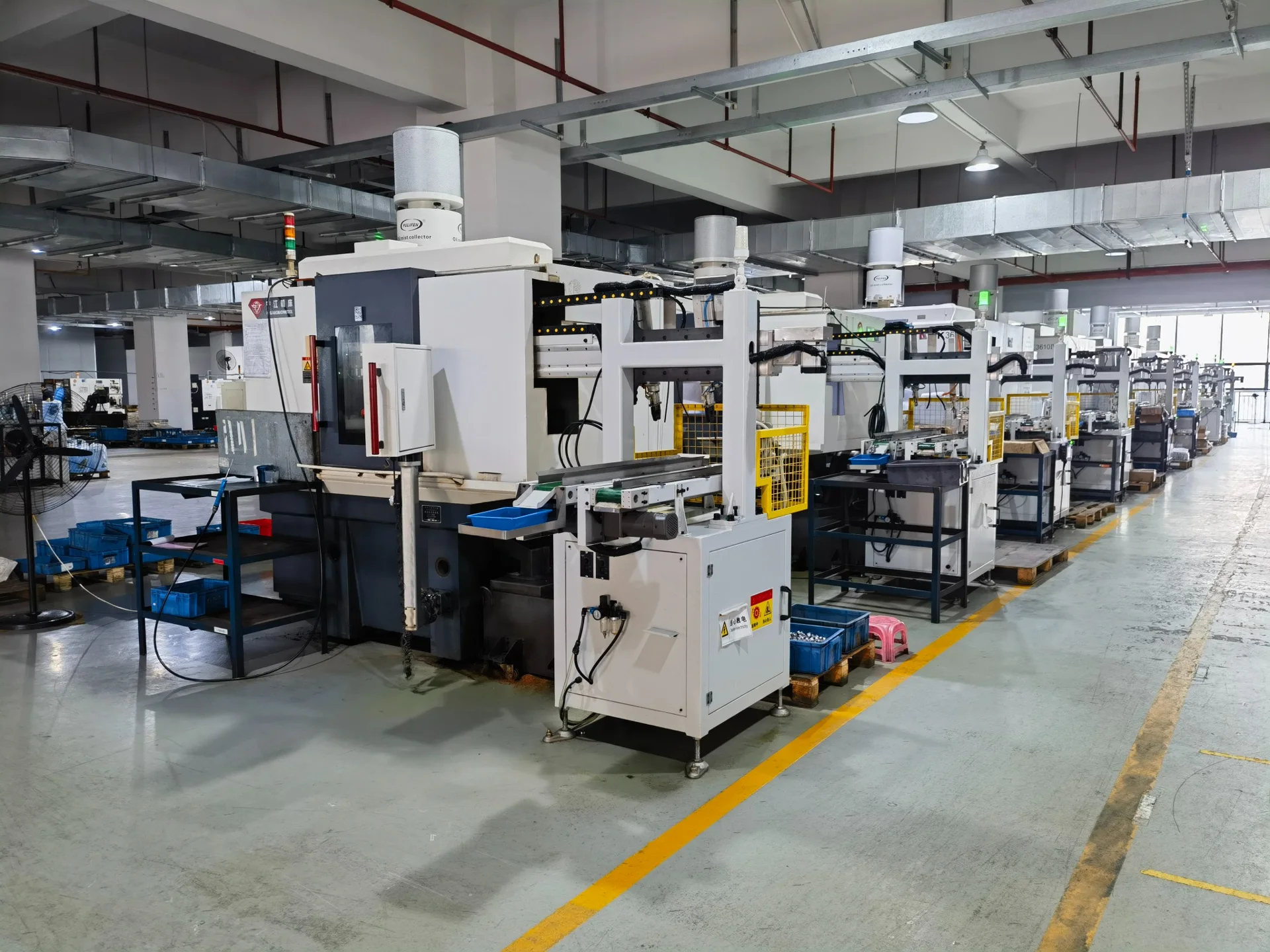 Rows of machining equipment beside a marked workshop aisle
