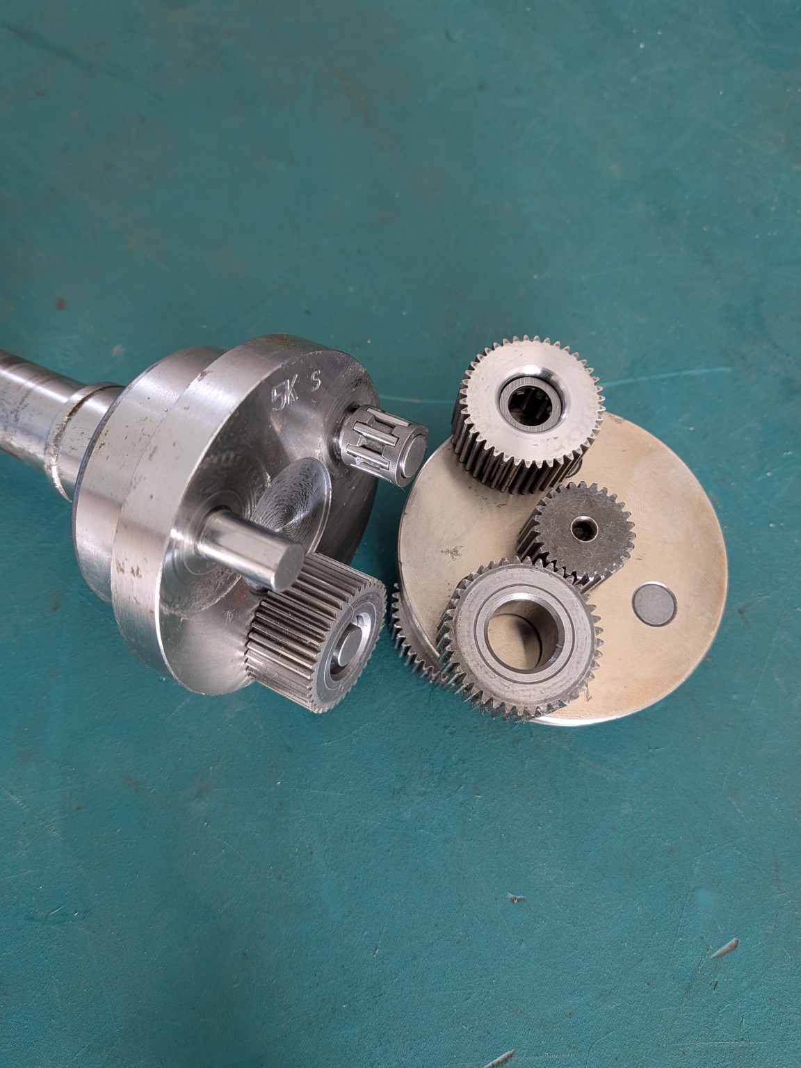 Disassembled PLF090 planetary gearbox showing Các bánh răng hành tinh, Giá đỡ hành tinh plates và a needle roller bearing on a planet pin